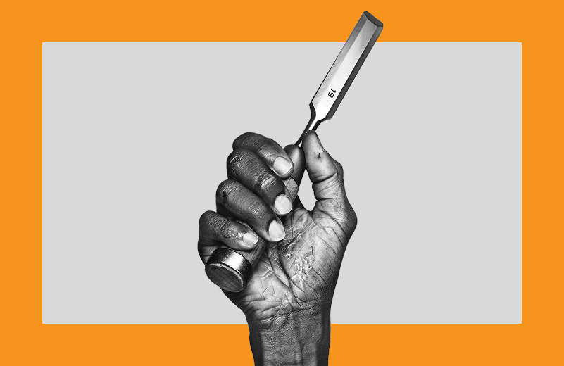Black and white photograph of a hand with moderate to severe hand eczema holding a chisel.