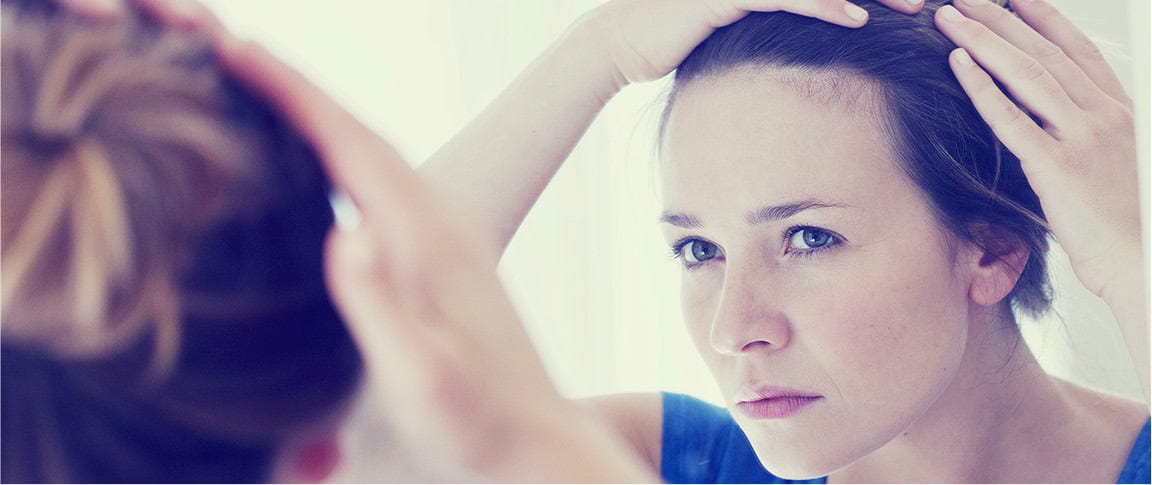 ragazza si guarda allo specchio i capelli