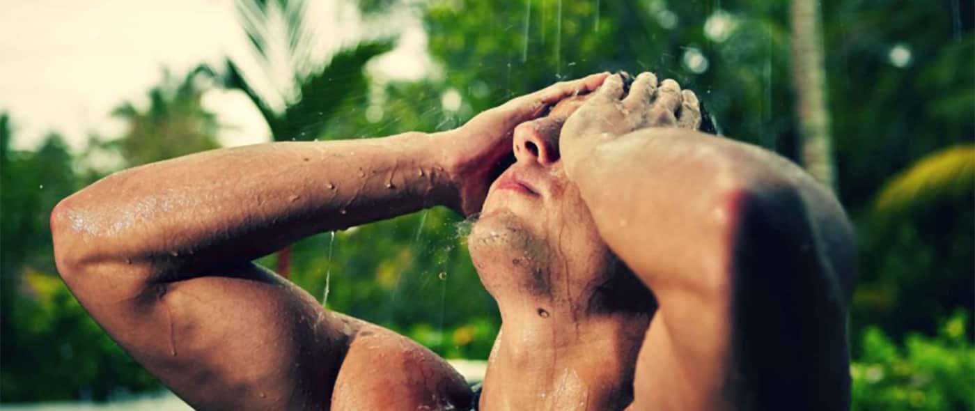 Un uomo si fa una doccia dopo il bagno al mare 
