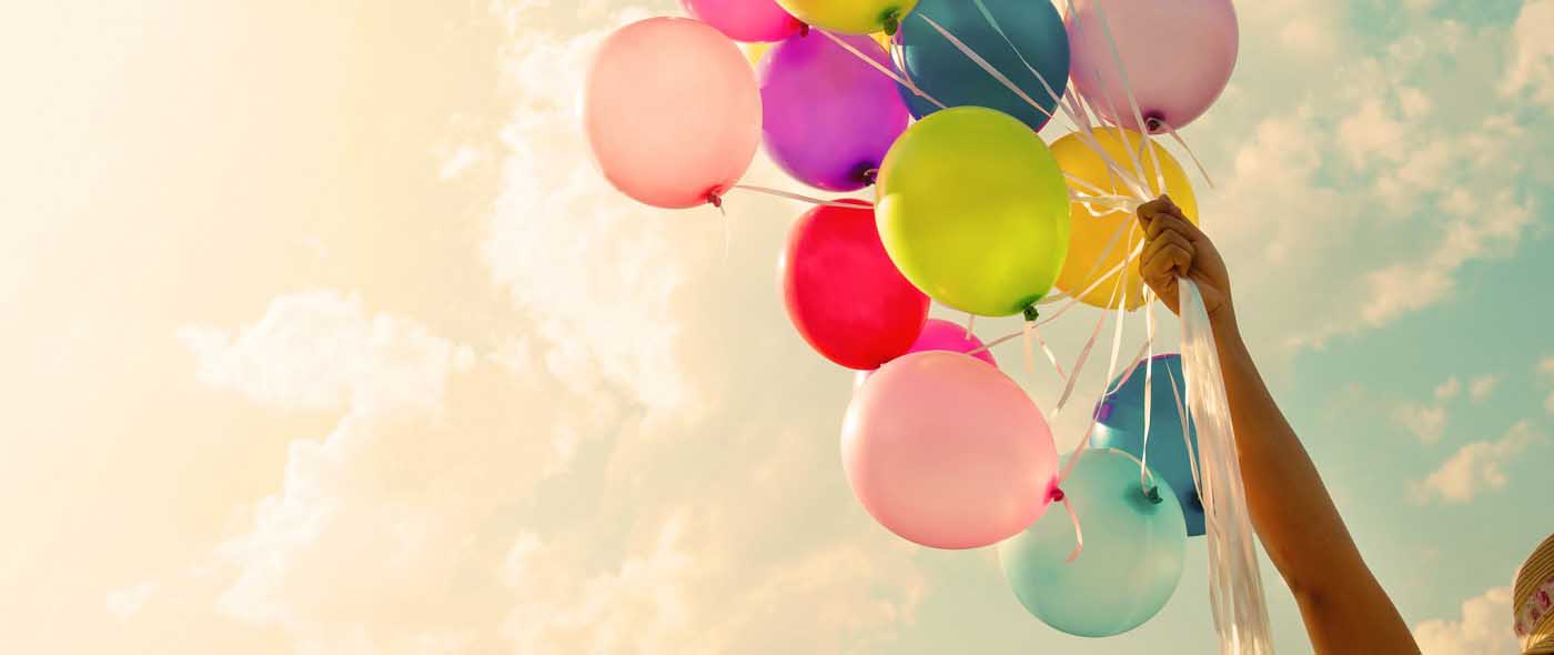 hand holding colourful balloons