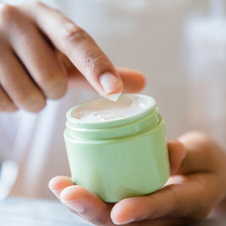 Hand holding over the counter eczema cream